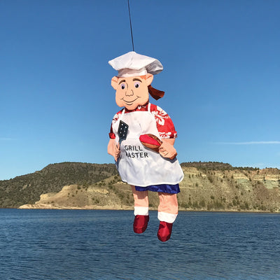 Grillin' Guy Wind Friend whimsical 3D garden decoration featuring a cheerful grill master design, swaying in the breeze on a patio.