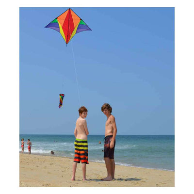 Gyro Delta Kite - Rainbow soaring high in the sky with colorful stripes, accompanied by a spinning windsock in an outdoor setting.