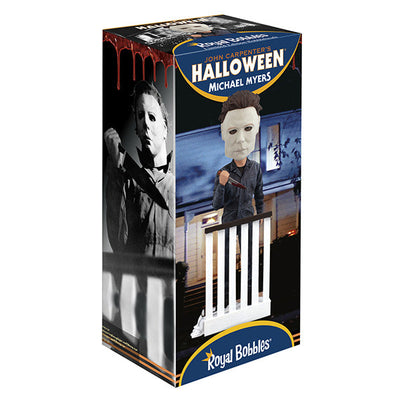 Halloween Michael Myers Bobblehead leaning over a stair railing, with a ghost sheet and glasses at his feet, capturing the essence of classic horror.