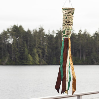 Happy Camper 40" Windsock shown outdoors, fluttering in the wind, bringing a cheerful touch to your garden or camping area with its bright, fun design.