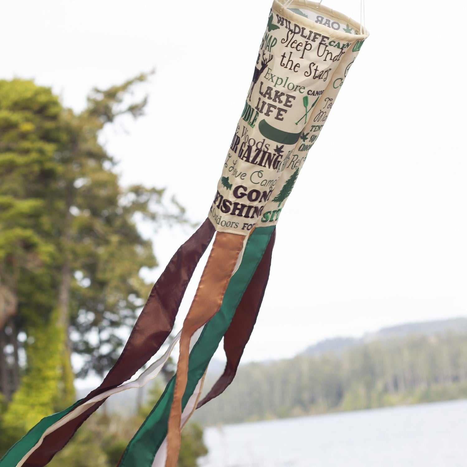 Happy Camper windsock featuring vibrant colors and detailed graphics, perfect for hanging outdoors in a garden or campsite setting to celebrate camping adventures.
