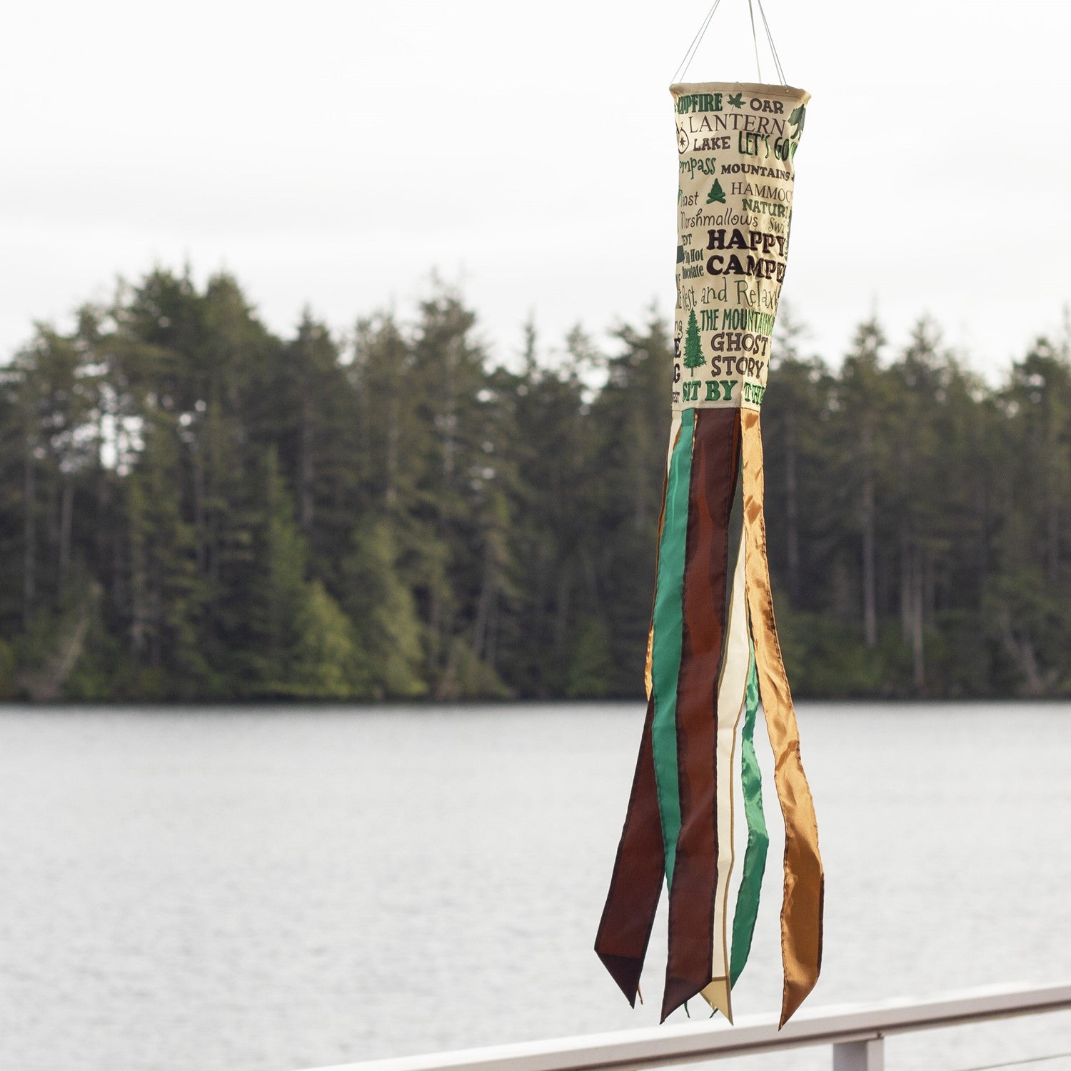 Happy Camper windsock featuring vibrant colors and detailed graphics, perfect for hanging outdoors in a garden or campsite setting to celebrate camping adventures.