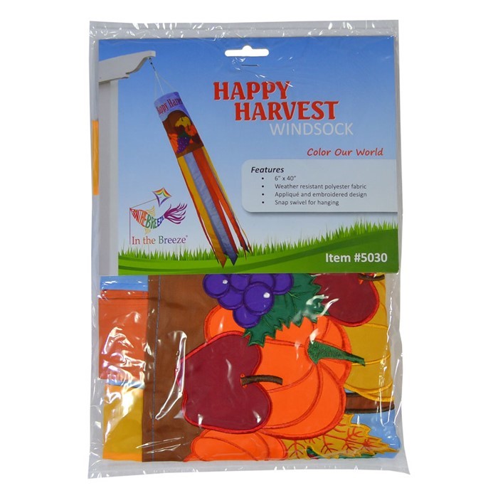 Happy Harvest 40" Windsock featuring a cornucopia design with fruits and vegetables, fluttering gracefully in a garden setting during autumn.