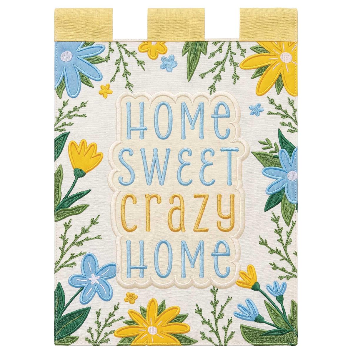 Home Sweet Crazy Home double-sided garden flag featuring vibrant designs and intricate appliques displayed outdoors in a garden setting.