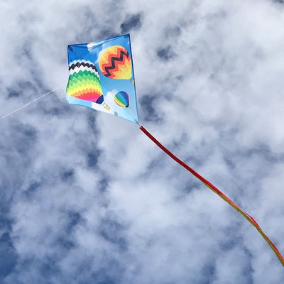 Hot Air Balloon 30" Diamond Kite with colorful design flying in a blue sky, showing vibrant colors and tails against a sunny backdrop.