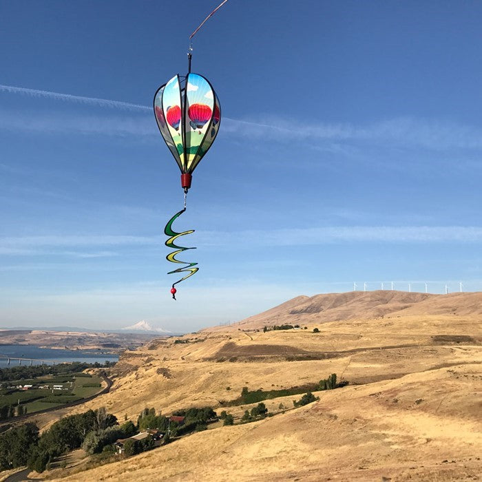 Colorful Hot Air Balloon spinner in vibrant fabric spinning in a garden setting, showcasing unique designs on each panel as it catches the wind.