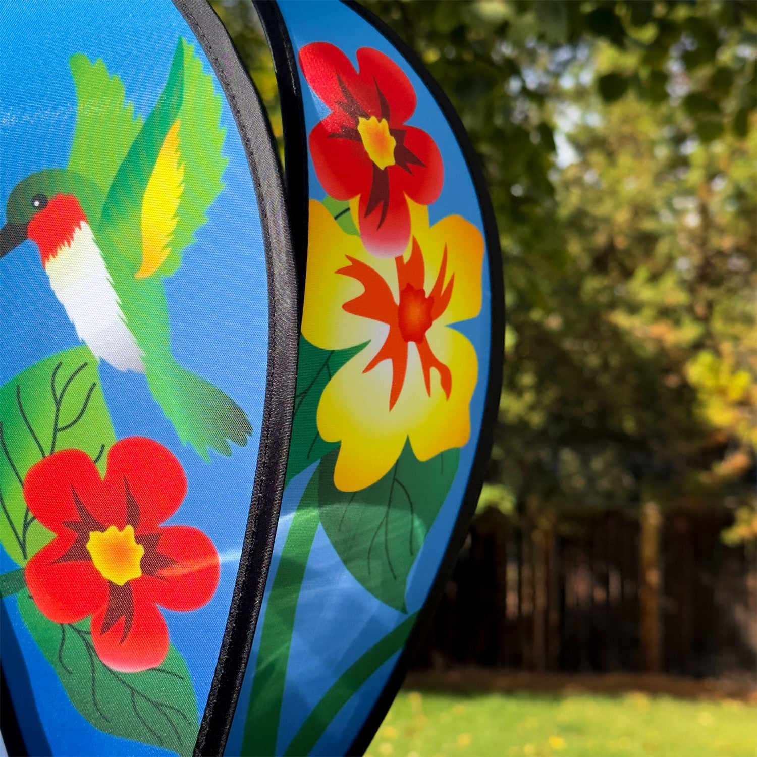 Hummingbird Flowers Hot Air Balloon spinner with colorful flower and hummingbird designs, spinning gracefully in an outdoor setting.