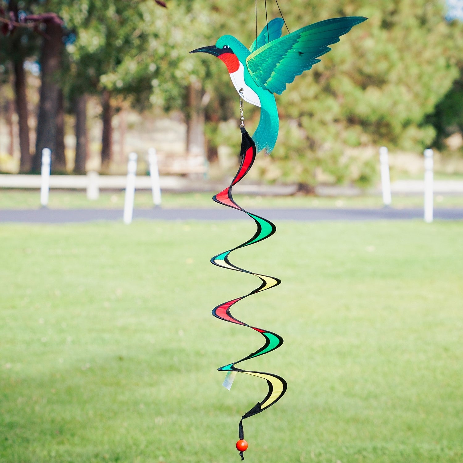 Hummingbird Theme Twister with moveable wings and curlie tail hanging in a garden, displaying vibrant colors and 3D design.