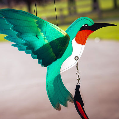 Hummingbird Theme Twister with moveable wings and curlie tail hanging in a garden, displaying vibrant colors and 3D design.