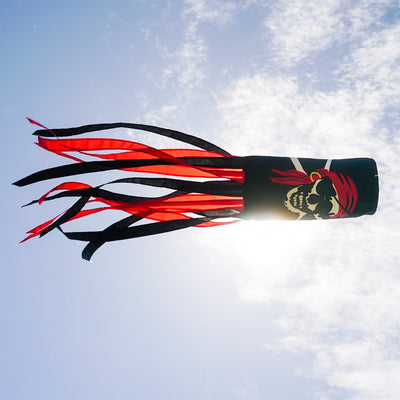 I'm a Jolly Roger 40" Windsock featuring a detailed pirate design with headscarf and gold earring, fluttering with vibrant tails in an outdoor setting.