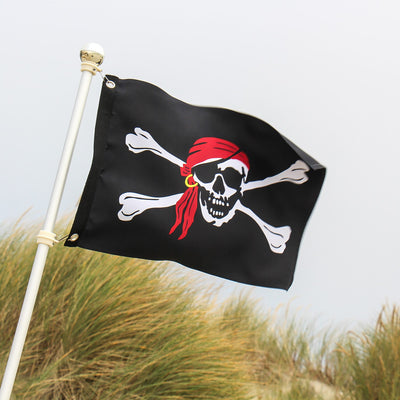 I'm a Jolly Roger Lustre 12x18 Grommet Flag featuring skull and crossbones design, displayed on a flagpole in a vibrant setting.