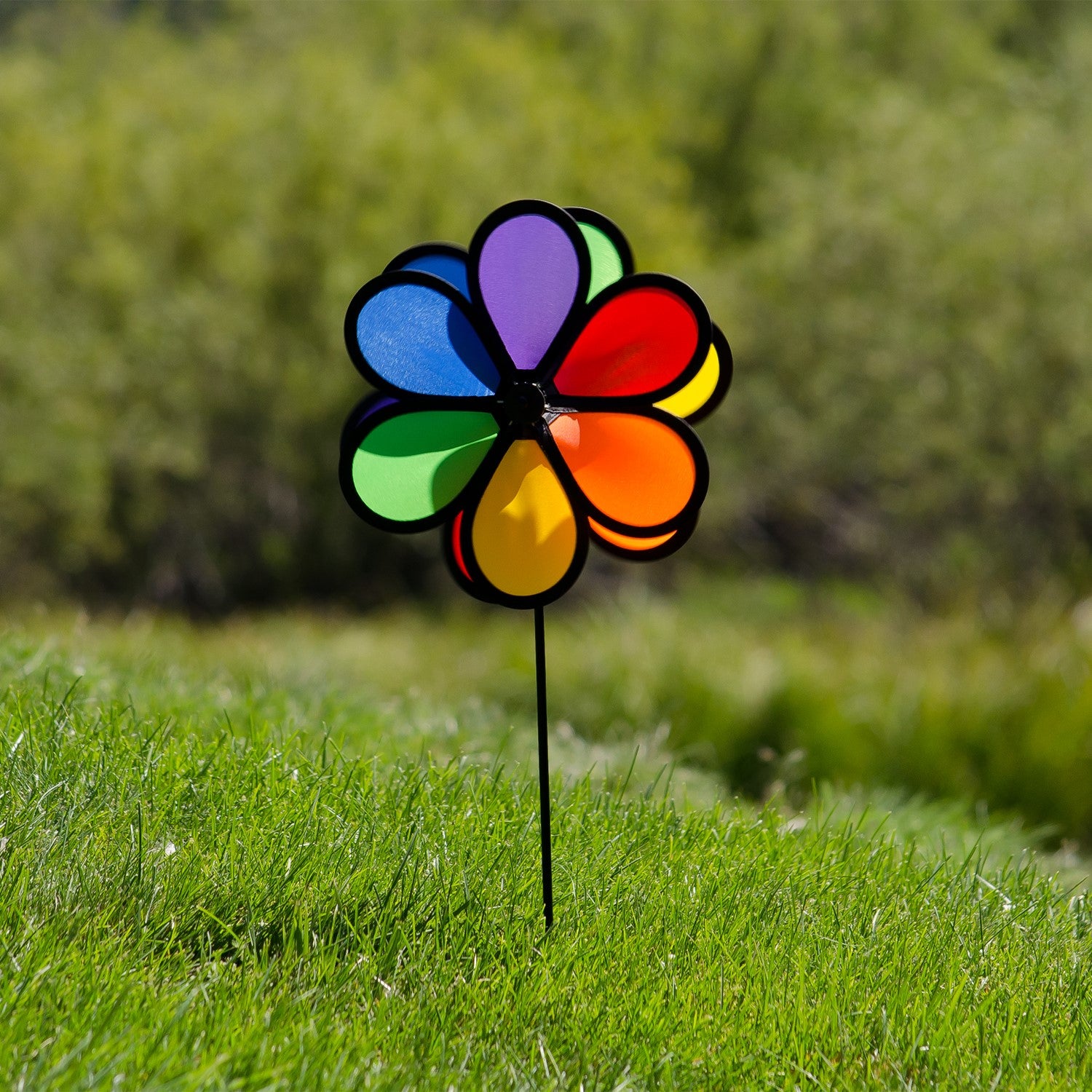 Alt text: "10-inch double flower spinner with two vibrant rainbow flower wheels rotating in opposite directions, displayed in a garden setting.