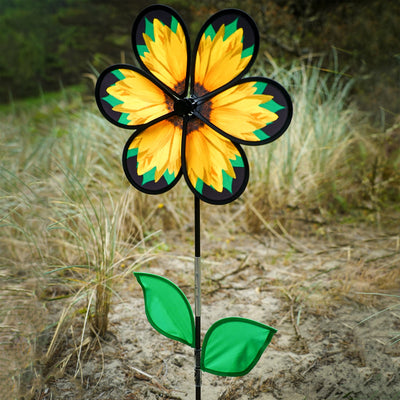 Alt Text: 13.5" sunflower spinner with six petals and green leaves displayed in a garden, twisting gently in the breeze on a fiberglass pole.