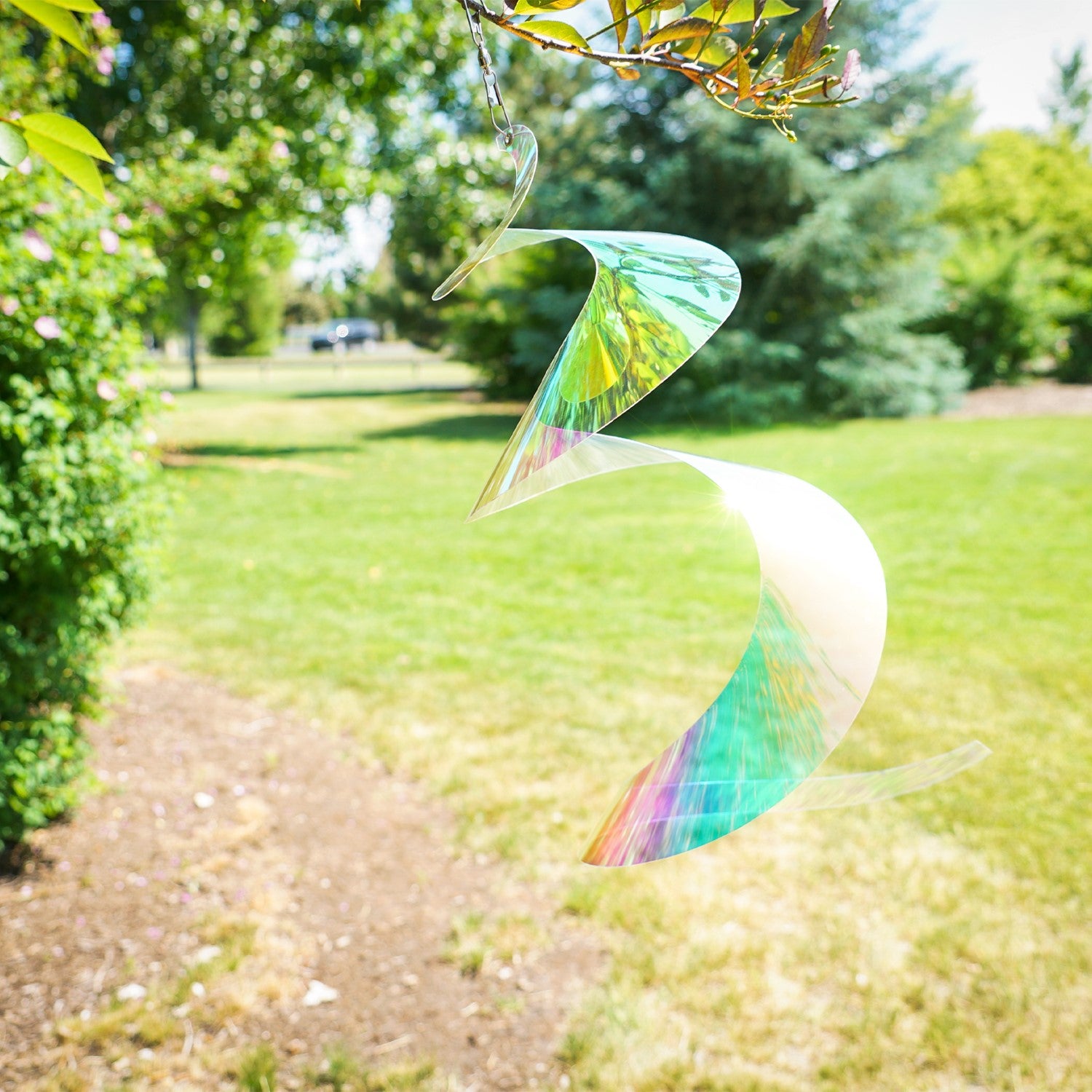 Alt Text: "30-inch iridescent twister tail made of Mylar, spinning gracefully in the sunlight, showcasing vibrant colors and reflections in an outdoor setting.