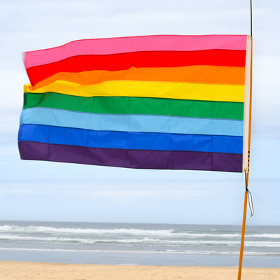 **Alt Text** Historic Pride 3x5 Grommet Flag displaying Gilbert Baker's eight-stripe design outdoors, symbolizing LGBTQ+ pride and diversity.