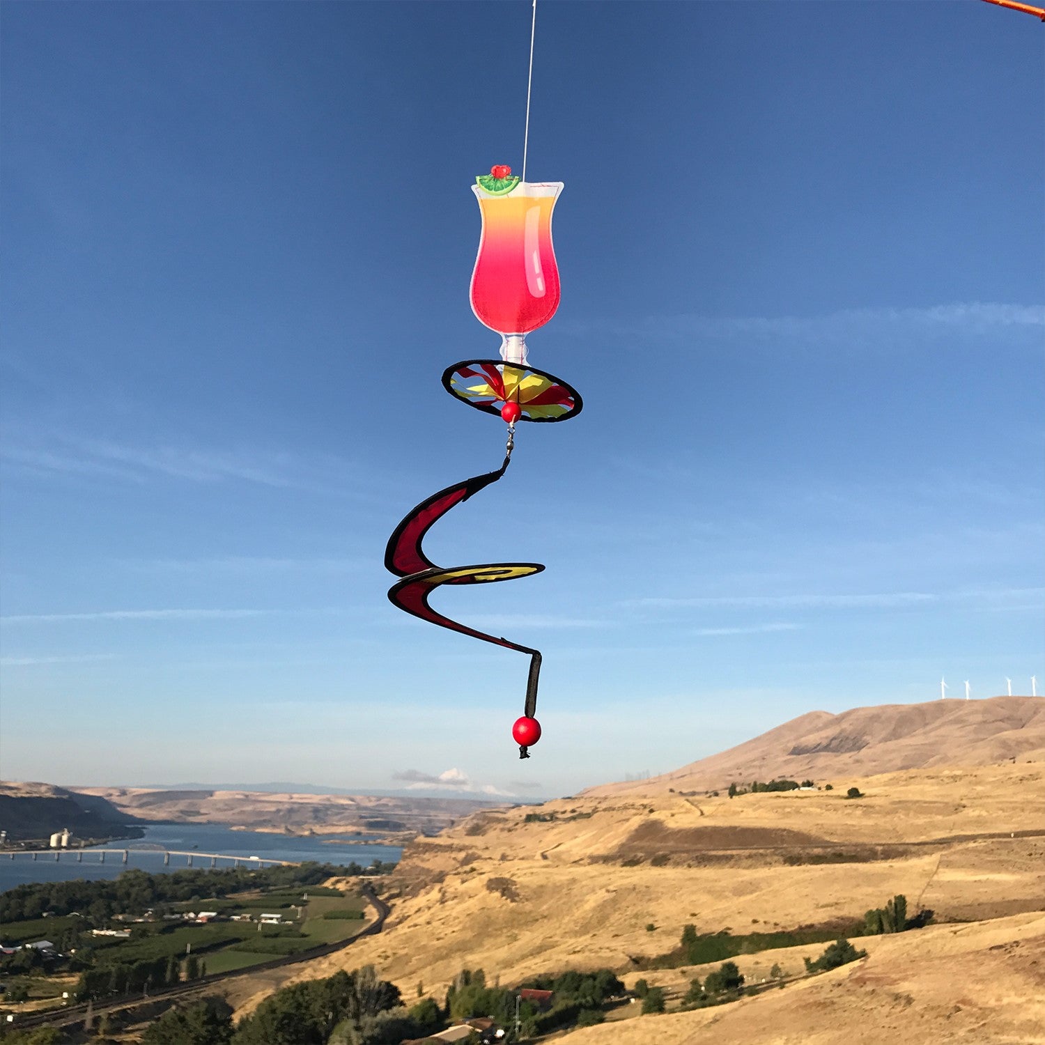 Alt Text = "Mini Cocktail 5 O'Clock Drink Spinner featuring a colorful cocktail glass design with a curlie tail, spinning in a garden setting.