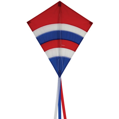 Alt Text: Patriotic Arch 27" Diamond Kite with vibrant colors and long tails flying against a blue sky during an outdoor family activity.