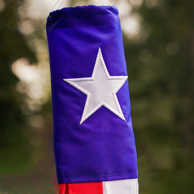 **Alt Text:** "Texas 18-inch windsock displaying the Texas flag and star, fluttering in the breeze with vibrant color-coordinated tails.