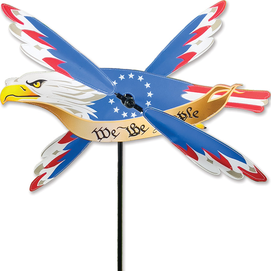18 in. Independence Eagle WhirliGig Spinner featuring a bald eagle and We the People banner, beautifully displayed in a garden setting.