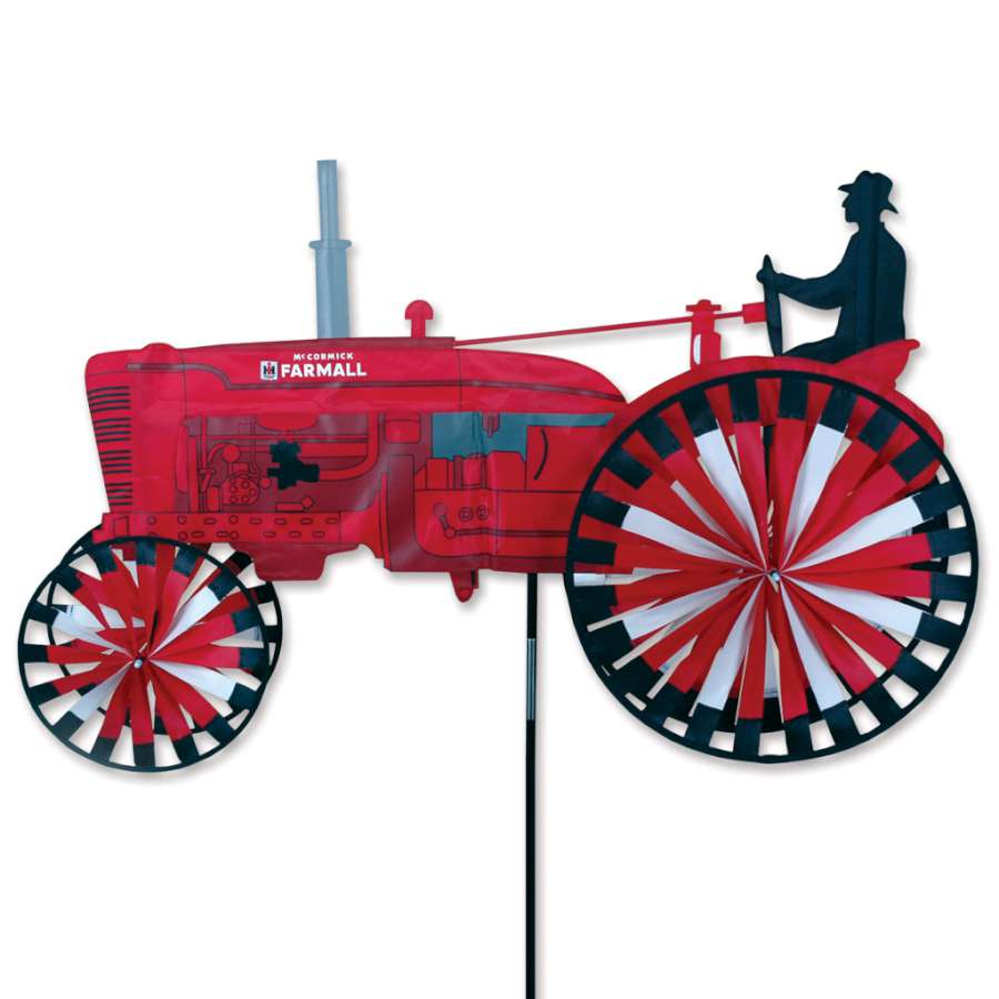 International Harvester Tractor Spinner with iconic logo spinning in the breeze, showcasing vibrant colors in an outdoor garden setting.