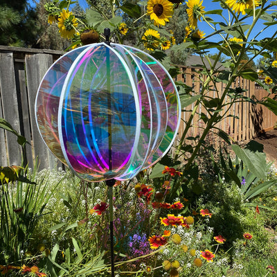 Iridescent 16-inch gazing ball spinner with six shimmering panels reflecting sunlight displayed in a vibrant garden setting.