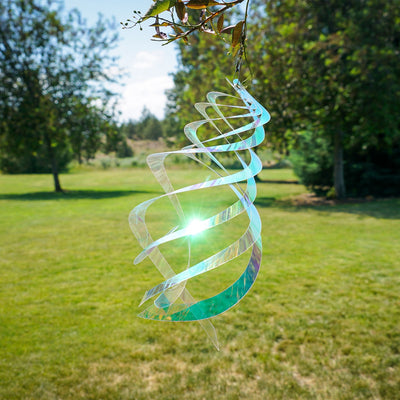 Iridescent Crystal Spinner made of Mylar, featuring five blades that spin smoothly in the breeze, creating a colorful display in a garden setting.