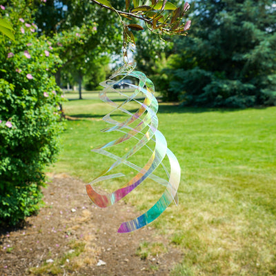 Iridescent Crystal Spinner made of Mylar, featuring five blades that spin smoothly in the breeze, creating a colorful display in a garden setting.