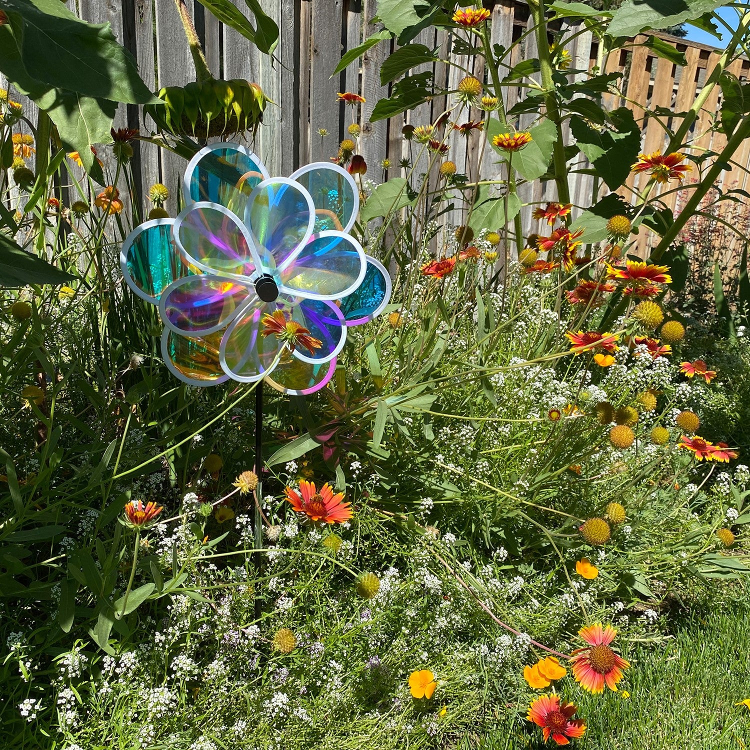 13.5-inch iridescent double flower spinner featuring two colorful flowers on a fiberglass pole, gracefully spinning in a garden setting.