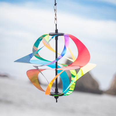 Iridescent Rainbow Vortex Spinner featuring six Mylar spirals hanging in a garden, shimmering in the breeze and reflecting light.