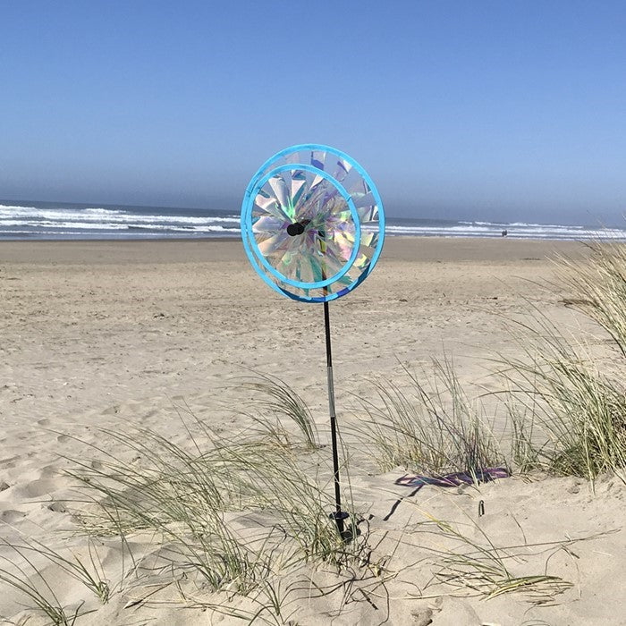 Iridescent Sparkle Double Wheel Spinner featuring dual wheels with reflective PVC material, spinning gracefully in a garden setting.