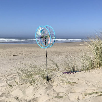 Iridescent Sparkle Duo Wheel Spinner with two colorful reflective wheels rotating in a vibrant outdoor garden setting.