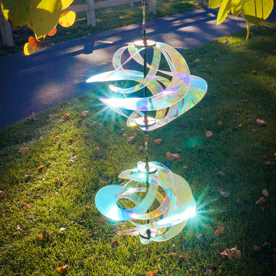 Iridescent Vortex Double Spinner showcasing interconnected Mylar spirals spinning in a sunny garden setting, creating a vibrant visual display.