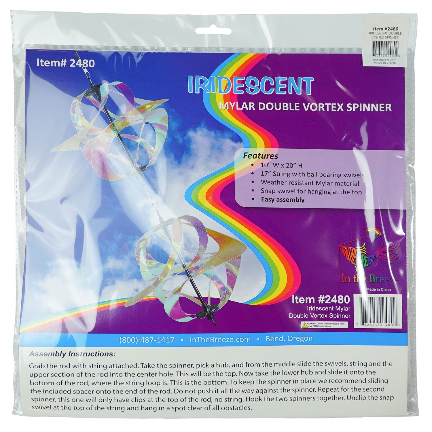 Iridescent Vortex Double Spinner showcasing interconnected Mylar spirals spinning in a sunny garden setting, creating a vibrant visual display.