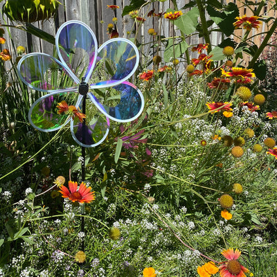 Colorful 13.5" Iridescent Windee Wheelz Spinner with transparent petals spinning in the garden under sunlight.