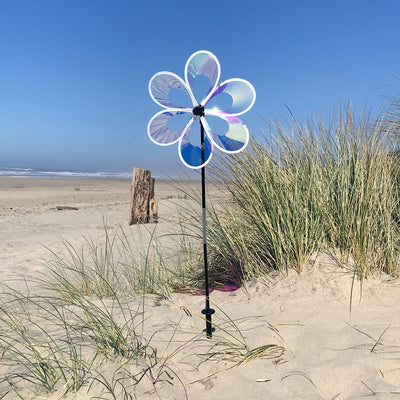 Colorful 13.5" Iridescent Windee Wheelz Spinner with transparent petals spinning in the garden under sunlight.
