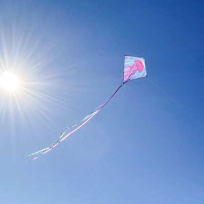 Jellyfish 30" Diamond Kite soaring against the blue sky with vibrant colors and tails, designed for easy flying.
