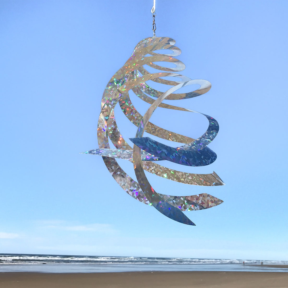 The Jewel Crystal Spinner displaying five reflective blades glimmering in sunlight, creating a spectrum of colors as it spins in a gentle breeze.