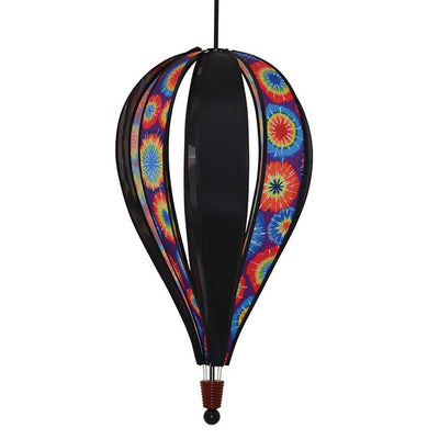 Jumbo Tie Dye 8-Panel Hot Air Balloon spinning in a garden, showcasing its colorful tie-dye design against a clear blue sky.