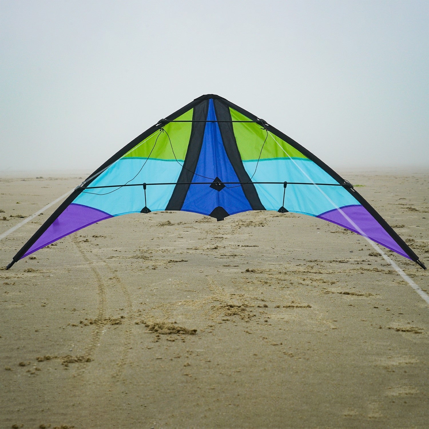 Kai 63' Sport Kite soaring against a bright blue sky, featuring vivid colors and a sleek two-line design ideal for outdoor enthusiasts.