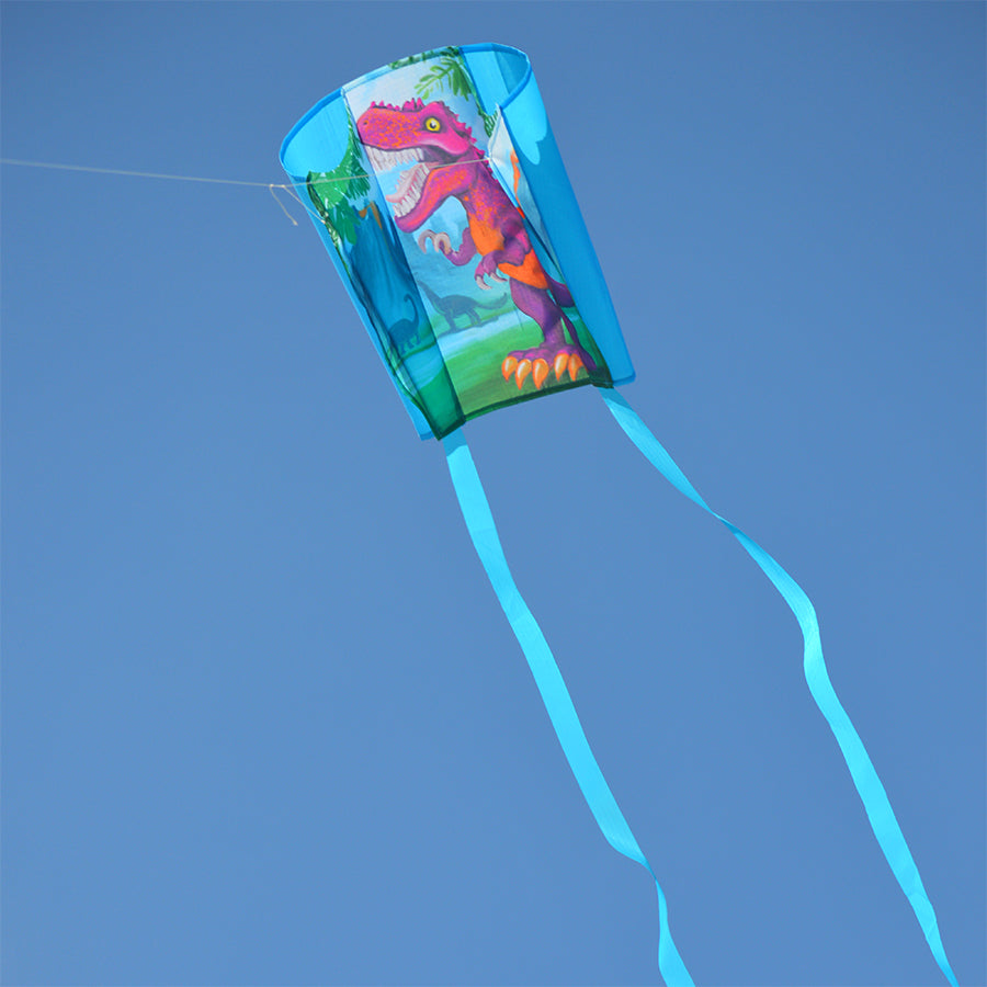 A colorful Keychain Kite - T-Rex with streamers flying in a blue sky, showcasing its fun design and compact size of 18 x 12.75 inches.