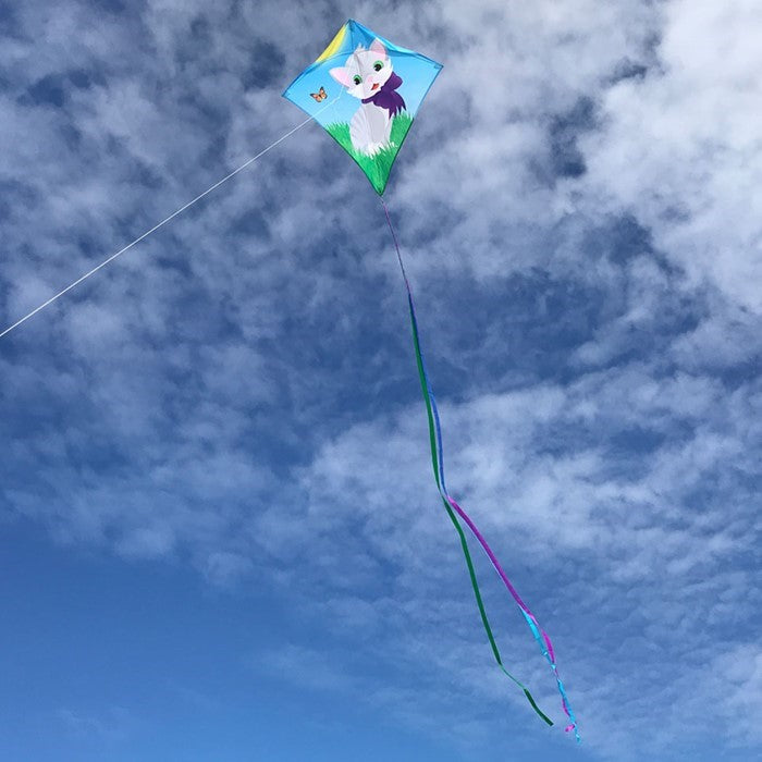 Colorful Kitten 30" Diamond Kite with a cheerful kitten design soaring against a bright blue sky, with tails fluttering in the wind.