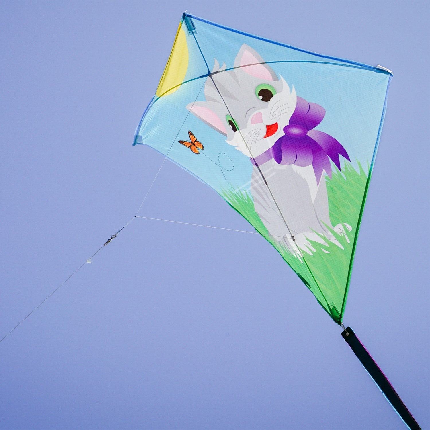 Colorful Kitten 30" Diamond Kite with a cheerful kitten design soaring against a bright blue sky, with tails fluttering in the wind.