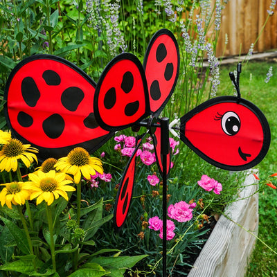 Ladybug Baby Spinner featuring a colorful 12-inch wheel on a sturdy fiberglass pole, designed for lively outdoor decoration in a garden setting.