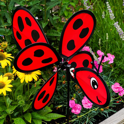 Ladybug Baby Spinner featuring a colorful 12-inch wheel on a sturdy fiberglass pole, designed for lively outdoor decoration in a garden setting.