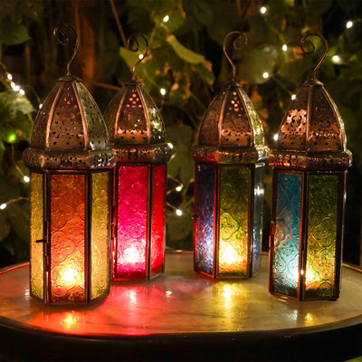 Large Blue & Green Hex Glass Tealight Lantern featuring stamped glass panels and metal frame, hanging gracefully in an outdoor setting.