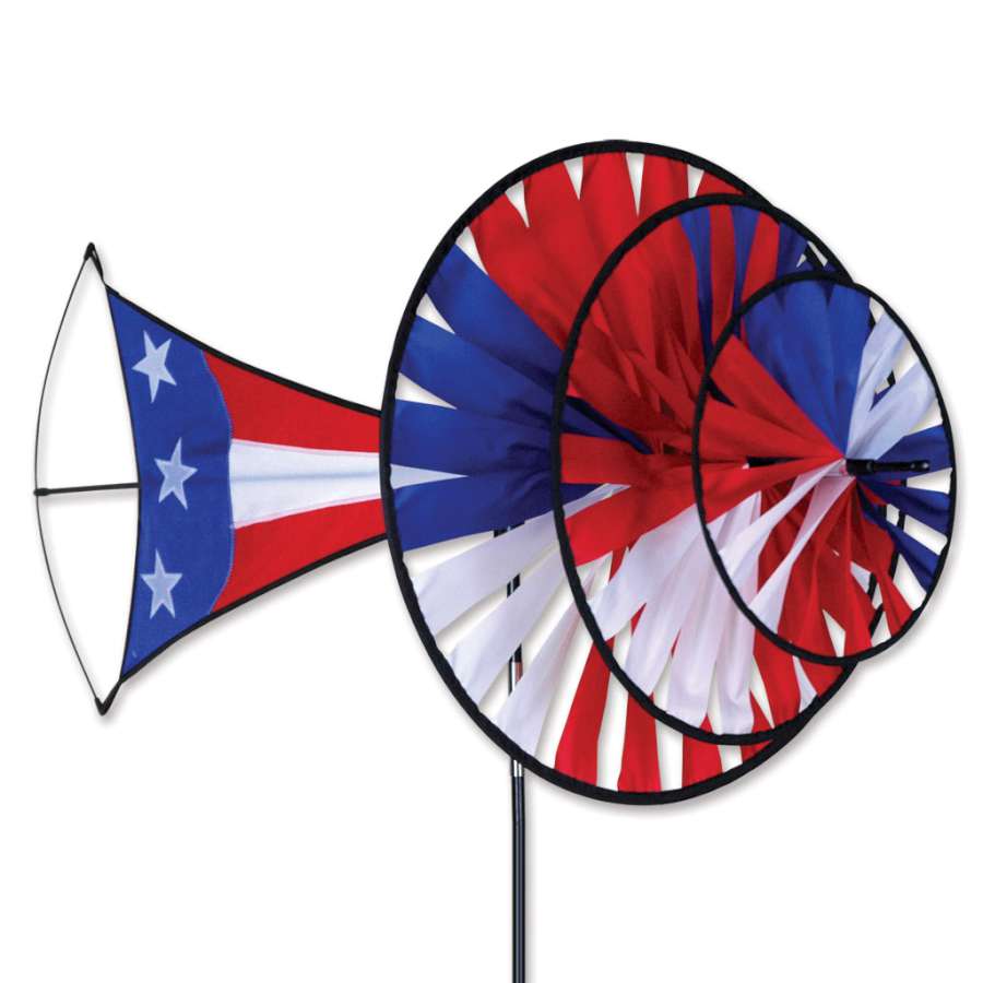 Large Patriotic Triple Spinner in red, white, and blue spinning gracefully in a garden setting against a clear blue sky.