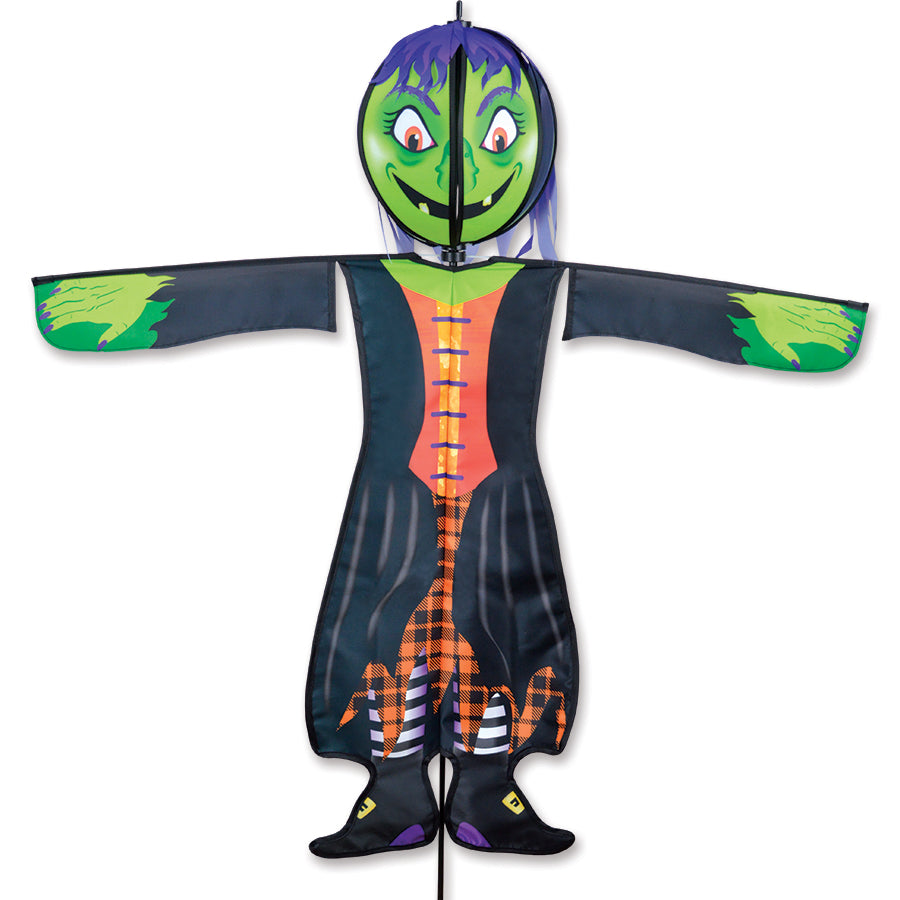 Large Spinning Friend Witch outdoor decoration featuring a colorful, playful design with a spinning head, poised on a plastic ground stake in a garden.