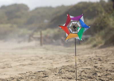 Laser Rainbow Kaleidoscope Ground Spinner featuring two colorful wheels spinning in a garden setting, designed for vibrant outdoor display.