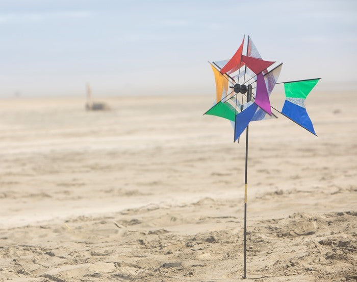 Laser Rainbow Kaleidoscope Ground Spinner featuring two colorful wheels spinning in a garden setting, designed for vibrant outdoor display.