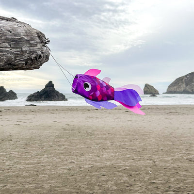 15-inch Lavender Damsel Fish windsock displaying colorful fins fluttering in the breeze against a garden backdrop.